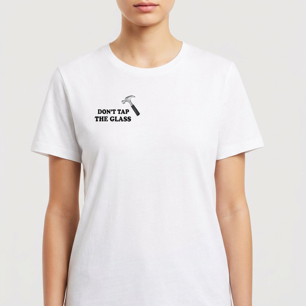 Camiseta com estampa frontal de martelo e texto "Don't Tap The Glass" e estampa traseira de rosto com boné, texto e blocos coloridos ao lado.