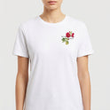 Camiseta com estampa frontal de flores delicadas acompanhadas da inscrição "Nós que aqui estamos".