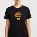 Camiseta com estampa frontal de texto "QUEM DECIDIU ISSO?" em formato de bigode e cabelos estilizados, e estampa traseira de personagem imponente nomeado "Escanor" em pose confiante, acompanhado de textos estilizados e elementos gráficos.