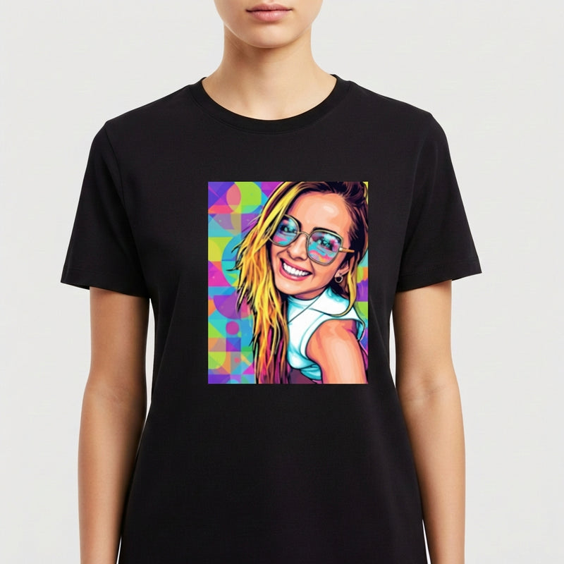 Camiseta com estampa frontal de retrato artístico de mulher sorridente com óculos, cabelo solto, sobre fundo geométrico colorido e vibrante.