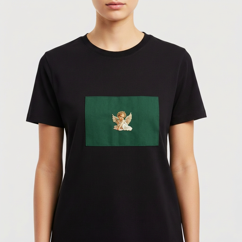 Camiseta com estampa frontal de anjo com asas brancas, repousando a cabeça sobre as mãos, destacando-se sobre um fundo retangular sólido.