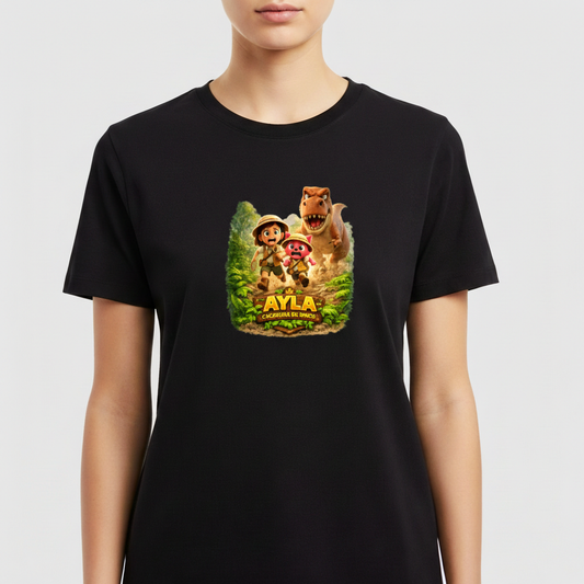 Camiseta com estampa frontal de exploradora ao lado de dinossauro e cachorro em cenário de selva, com o texto "Ayla a Caçadora de Dinos".