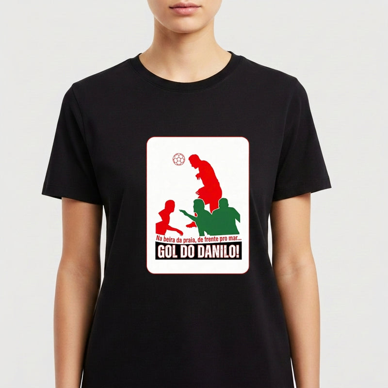 Camiseta com estampa frontal de silhueta de jogador de futebol em ação, bola à frente, cercado por outras figuras e textos em destaque.