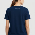 Camiseta com estampa frontal de linhas horizontais estilizadas atravessadas por uma forma circular e estampa traseira com texto pequeno "Moda de Unic" sob a gola.