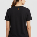 Camiseta com estampa frontal de texto em quatro linhas: "LATINA, BRASILEIRA, FORROZEIRA, RESISTÊNCIA" e estampa traseira de pequeno espiral centralizado.