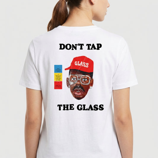 Camiseta com estampa frontal de martelo e texto "Don't Tap The Glass" e estampa traseira de rosto com boné, texto e blocos coloridos ao lado.