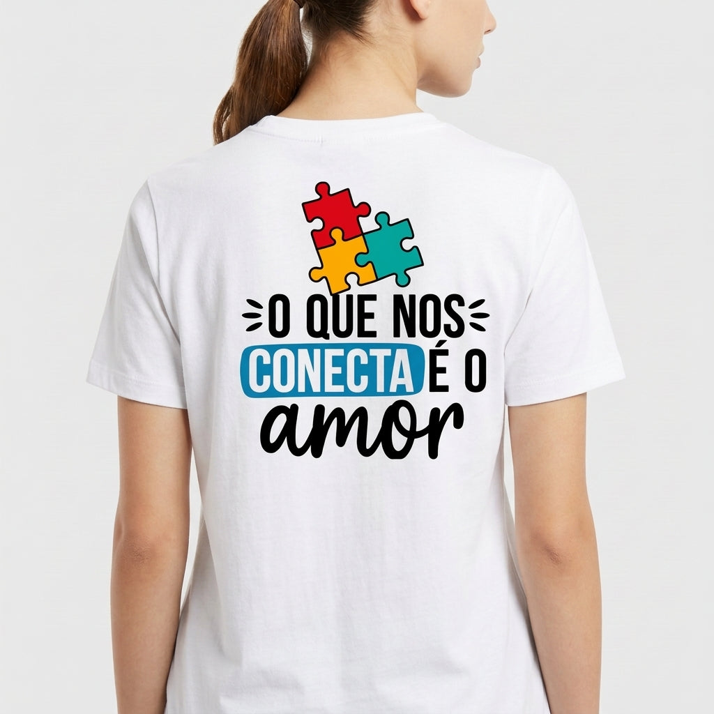 Camiseta com estampa frontal de "AUTISMO" acompanhado de mãos e frase "Ser diferente é normal" e estampa traseira de peças de quebra-cabeça com "O QUE NOS CONECTA É O amor".