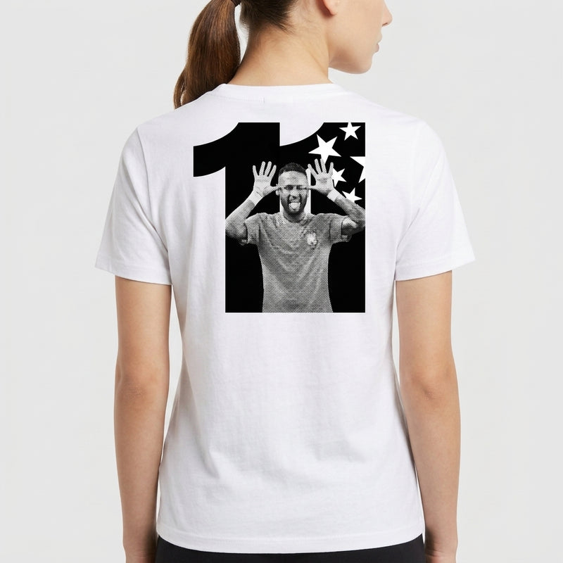 Camiseta com estampa traseira de número grande acompanhando imagem central de jogador de futebol em pose alegre, ladeado por estrelas estilizadas.