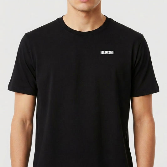 Camiseta com estampa frontal de texto "ESCAPES ME" em letras maiúsculas localizadas no peito, proporcionando um design minimalista e impactante.