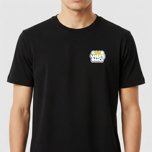 Camiseta com estampa frontal de frase "Good Vibes Only" em estilo tipográfico cheio, com detalhes circulares, destacando-se em camadas sobrepostas.