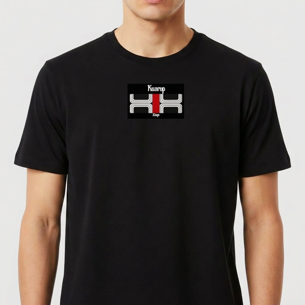 Camiseta com estampa frontal de texto "Kuarup" acima de um símbolo geométrico preto e branco com detalhe central em vermelho, e estampa traseira de símbolo menor similar.