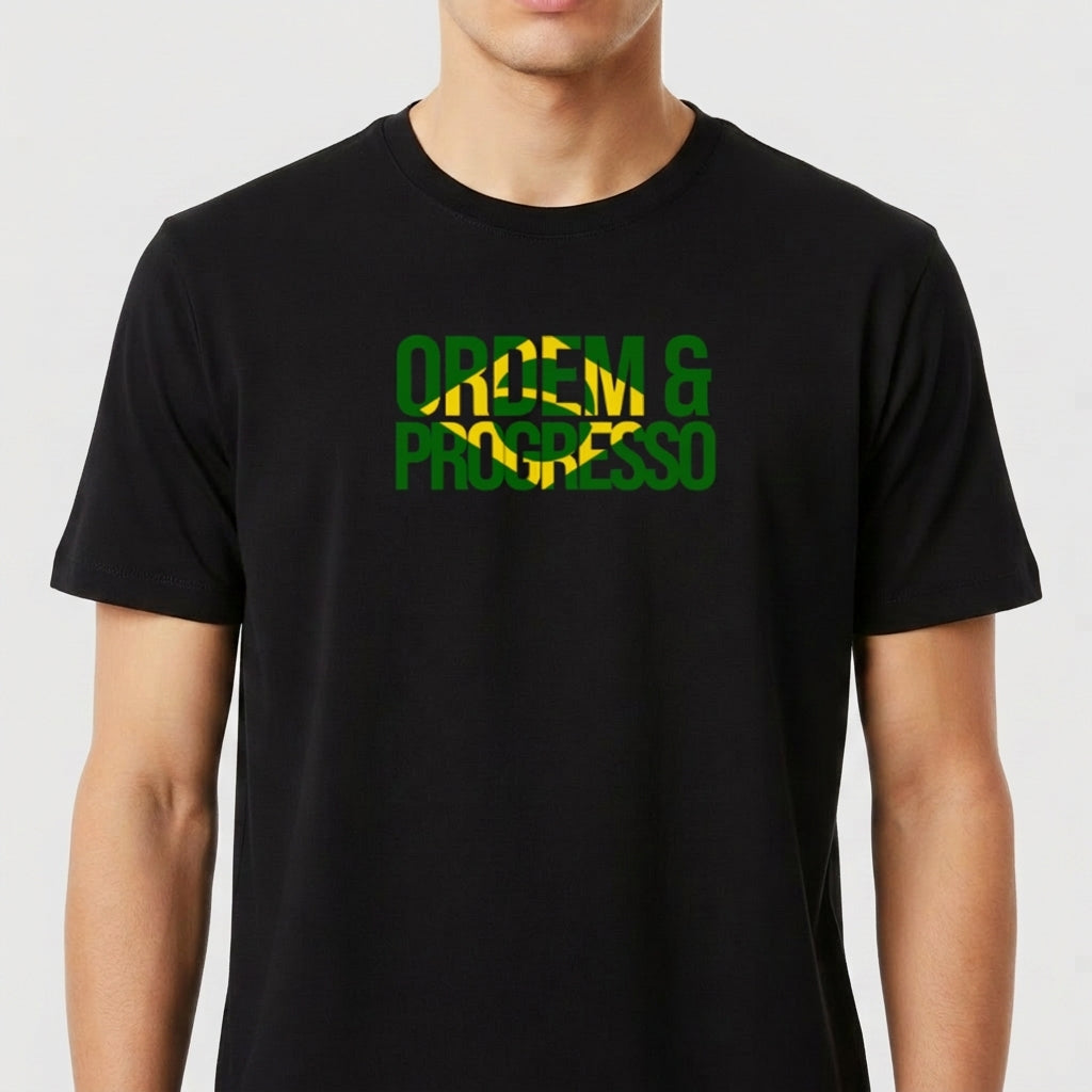 Camiseta com estampa frontal de "ORDEM & PROGRESSO" sobre uma bandeira fragmentada do Brasil e estampa traseira com "ELEVEN" e um pequeno símbolo.