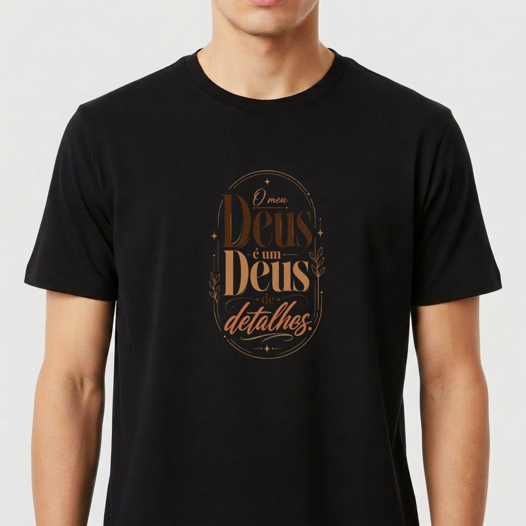 Camiseta com estampa frontal de texto estilizado "O meu Deus é um Deus de detalhes" e estampa traseira com pequeno logotipo "Santa Veste" acima de cruz.