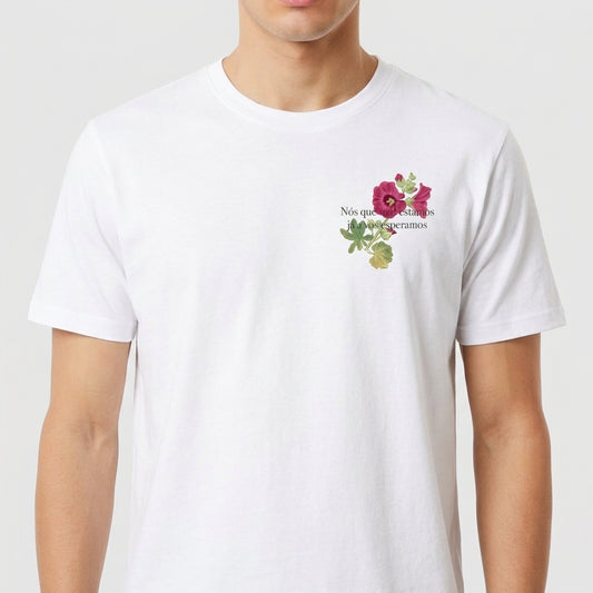 Camiseta com estampa frontal de flores delicadas acompanhadas da inscrição "Nós que aqui estamos".