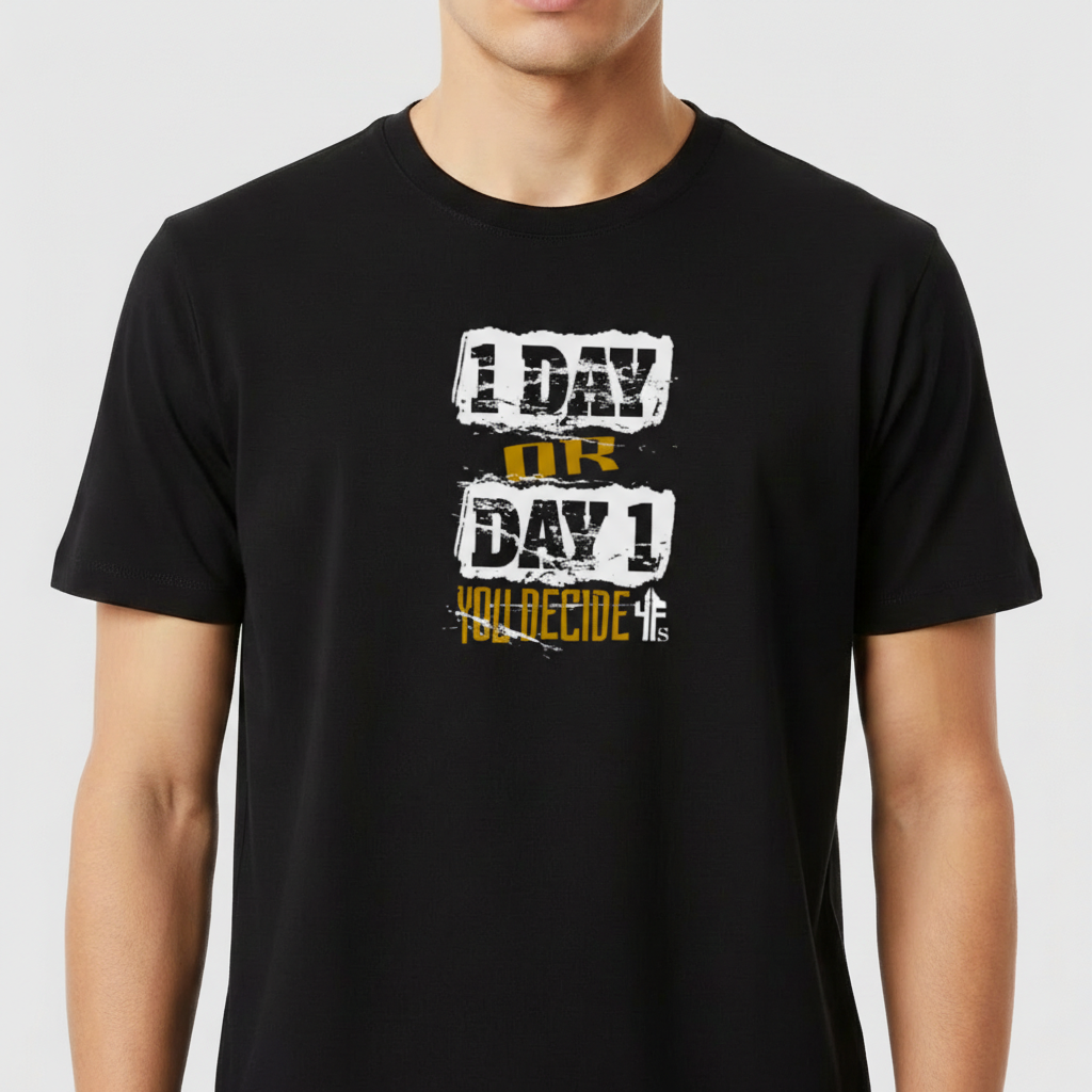 Camiseta com estampa frontal de texto em fontes variadas: "1 DAY OR DAY 1 YOU DECIDE", combinando estilos desgastados em branco e dourado.