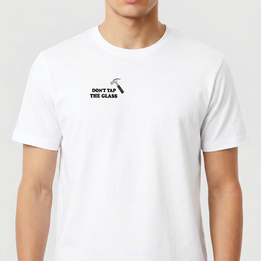 Camiseta com estampa frontal de martelo e texto "Don't Tap The Glass" e estampa traseira de rosto com boné, texto e blocos coloridos ao lado.