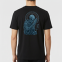Camiseta com estampa frontal de cruz estilizada e "Legio" e estampa traseira de esqueleto rezando, rodeado de caveiras e halo envolvente com letras.