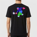 Camiseta com estampa frontal de lettering colorido e elementos circulares, e estampa traseira de personagem em ação jogando squash com raquete e bola.