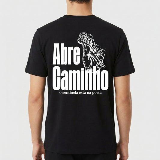 Camiseta com estampa traseira de mão segurando uma chave intricada ao lado das palavras "Abre Caminho" e uma frase menor abaixo, em estilo imponente.