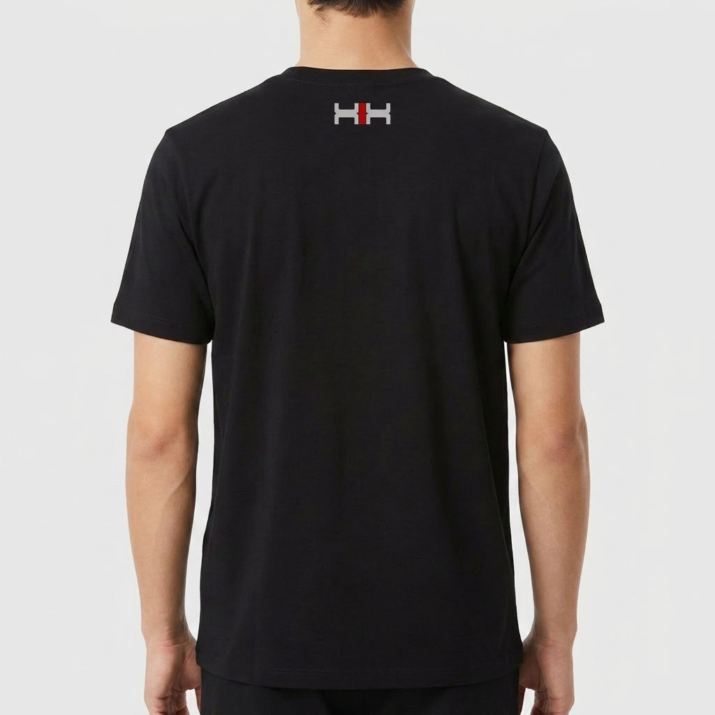 Camiseta com estampa frontal de texto "Kuarup" acima de um símbolo geométrico preto e branco com detalhe central em vermelho, e estampa traseira de símbolo menor similar.