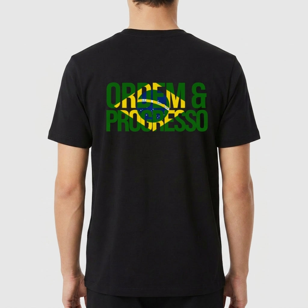 Camiseta com estampa frontal de "ORDEM E PROGRESSO" dentro de um retângulo e símbolo central, e estampa traseira com a mesma frase sobre bandeira estilizada.