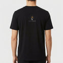 Camiseta com estampa frontal de contorno de figuras icônicas abraçando um bebê e texto abaixo, e estampa traseira de logo estilizado com coroa acima de texto.
