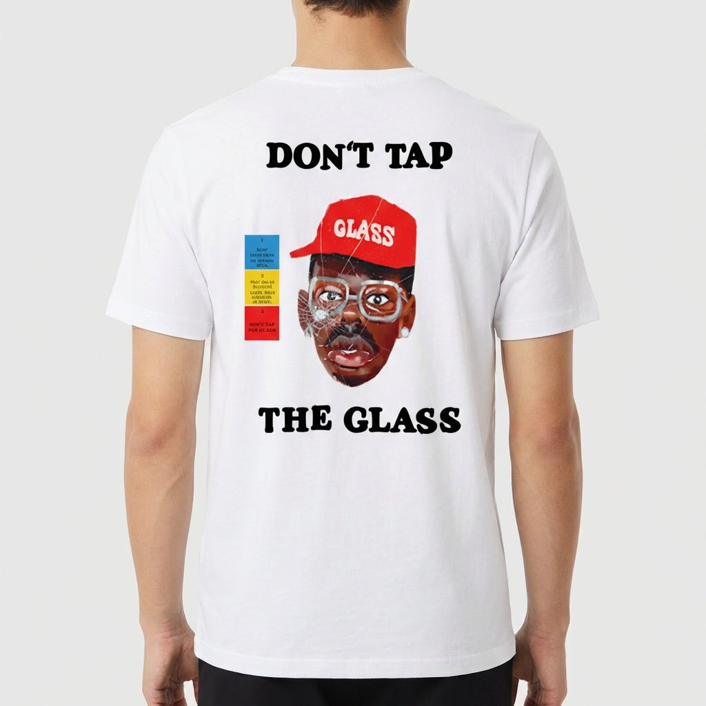 Camiseta com estampa frontal de martelo e texto "Don't Tap The Glass" e estampa traseira de rosto com boné, texto e blocos coloridos ao lado.