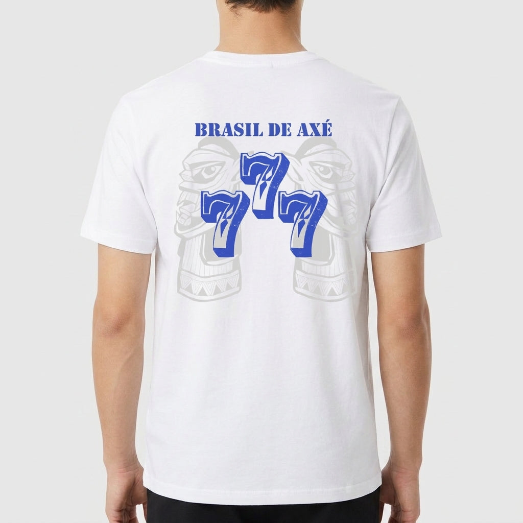 Camiseta com estampa frontal de brasão detalhado e estampa traseira de "Brasil de Axé" com números "777" estilizados sobre imagem difusa de elementos culturais.