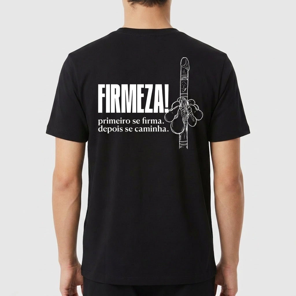 Camiseta com estampa traseira de mão fazendo gesto e com as palavras "FIRMEZA!" em destaque acima de frase inspiradora sobre firmeza e caminhada.